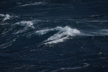 Wall Mural - dark ocean waves create dramatic scene with foamy crests and turbulent waters, evoking sense of powe