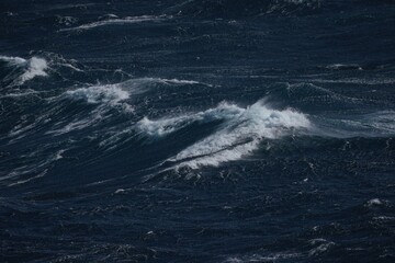 Wall Mural - dark ocean waves create dramatic scene, showcasing power and beauty of nature. turbulent water refle