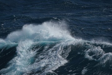 Wall Mural - dynamic ocean waves crashing with white foam against deep blue sea, creating sense of power and tran