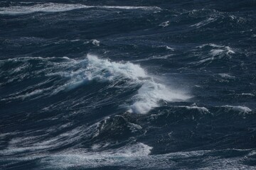 Wall Mural - dark ocean waves crashing with white foam, creating dramatic seascape. turbulent water reflects powe