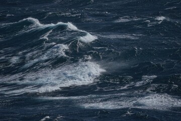 Wall Mural - rough ocean waves crashing against each other create dramatic seascape. deep blue water contrasts wi