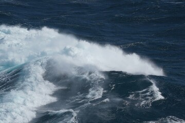 Wall Mural - powerful ocean waves crashing against each other, creating dramatic scene of white foam and deep blu