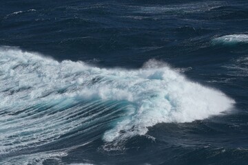 Wall Mural - dynamic ocean waves crashing against shore, showcasing power and beauty of nature. deep blue water c
