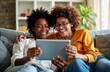 © miss irine - Happy lesbian couple uses tablet at home. Two smiling women relax on sofa. Diverse girls enjoy leisure time. Romantic same sex partners hug. Online shopping or gaming fun.