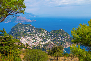 Wall Mural - The photo offers a scenic view from the cable car to Anacapri, Italy, showcasing sweeping landscapes, vibrant greenery, and the azure sea, capturing the beauty of this stunning island route.