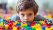 © Pichitpon - A little boy concentrating as he builds a multi-colored wooden bridge on a clean white background
