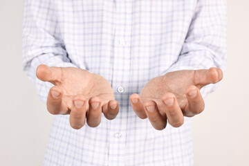 Wall Mural - man holding something on light grey background, closeup
