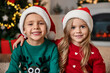 © New Africa - Cute little kids with Santa hats in room decorated for Christmas
