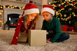 © New Africa - Little kids opening magic Christmas box on floor at home