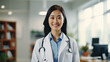© PulseImages - Smiling Asian female doctor in lab coat standing in hospital corridor
