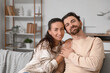 © Pixel-Shot - Married couple sitting on sofa at home