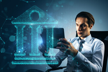 Sticker - Businessman using a tablet with a glowing holographic bank icon, modern digital banking concept, futuristic blue background.