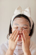 © zheng qiang - 家の中で風呂上がりの十代の女性が顔にシートマスクを使ってスキンケアする様子