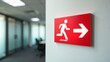 © Trust Fish - Illuminated emergency exit sign mounted on office wall directing to safety