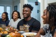 © alisya - Happy African American family enjoying dinner together at home.