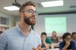 © ngamaz - Smiling male professor lecturing students in classroom.