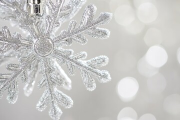 Wall Mural - sparkling silver snowflake ornament against bokeh lights
