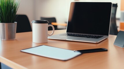 Poster - A modern office desk showcasing a laptop, coffee cup, tablet, and plant, ideal for productive work sessions during the day