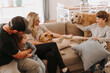 © Austockphoto - Happy family with two kids and dogs together on lounge in loungeroom at home