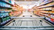 © Onetrick - supermarket shelves aisle with empty shopping cart defocused interior blur bokeh light background new