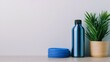 © Zara Elara HappyLife - Blue water bottle and green plant on a simple table.