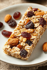 A homemade energy bar made from oats, nuts, and dried fruits, served on a plate