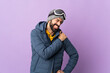 © luismolinero - Skier man with snowboarding glasses over isolated purple background suffering from pain in shoulder for having made an effort