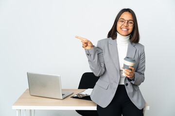 Wall Mural - Young latin business woman working in a office isolated on white background pointing finger to the side