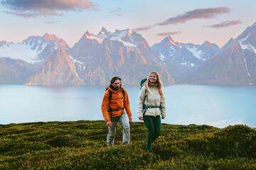 Wall Mural - couple climbing mountains in norway man and woman friends travel together active vacations tour heal