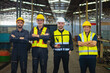 © lovelyday12 - Four men in safety vests stand together in a factory. They are wearing hard hats and safety gear