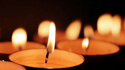 Wall Mural - Glimmer of Hope: A single candle flame stands out against a backdrop of flickering light, symbolizing hope, resilience, and the enduring power of light in darkness.  