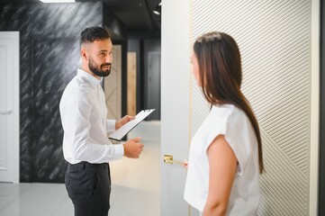 Wall Mural - A salesman advises a female customer on the choice of interior doors in a hardware store