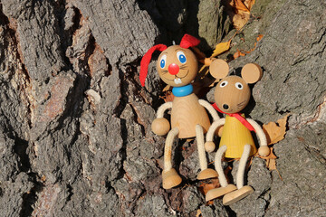 Wall Mural - Bunny and mouse - traditional painted wooden toys perched at a tree trunk