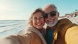 © Generative ART - Happy senior couple enjoying a sunny day at the beach, capturing memories with a selfie by the ocean.