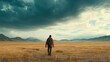 © Kitta Studio - Solitary Explorer Walking Through a Vast Open Field Under a Dramatic Sky with Rolling Clouds in a Scenic Landscape