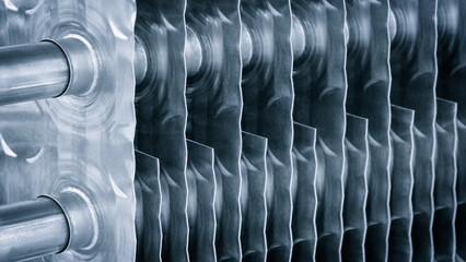 Poster - Dairy machine cooling radiator with a row of stainless steel metal pipes with silver trim. The pipes are connected to each other and appear to be part of a larger system
