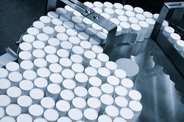 Poster - Row of white plastic containers with lids for medicines or vitamins or active dietary supplements on conveyor belt of pharmaceutical factory
