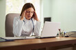 © Goran - Worried female doctor working in the office.
