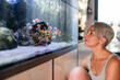 © milanmarkovic78 - Woman Enjoys Looking at the Aquarium