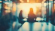 © Seyyar - Blurred figures engaged in work at desks, ambient light filtering through an office space, creating a tranquil atmosphere.