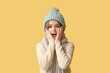© Pixel-Shot - Cute little shocked boy in winter clothes on yellow background