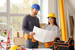 © Pixel-Shot - Young couple with plan during repair in their new house