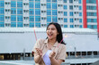 © M Alfan Setyawan - excited asian young woman holding sparkler to celebrating new year eve in rooftop apartment with city building background