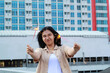 © M Alfan Setyawan - happy asian young woman hipster holding sparklers firework celebrate new year eve with dancing in roof top apartment with urban building background