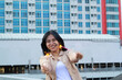 © M Alfan Setyawan - happy asian young woman hipster holding sparklers firework celebrate new year eve with dancing in roof top apartment with urban building background