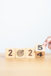 © Jo Panuwat D - 2024 year change to 2025 year block with dartboard icon. Goal, Target, Resolution, strategy, plan, Action, mission, motivation, and New Year start concepts