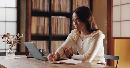 Wall Mural - Writer, typing and woman in home office with laptop, research or business plan for freelance project. Remote work, connectivity and Japanese person at desk writing notes, article or online report