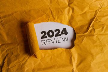 a yellow piece of paper with a hole torn in it. through the hole, a white piece of paper is visible 