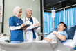 © NINENII - Female Doctor and Assistant Examining Male Patient's Health.