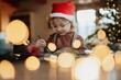 © Halfpoint - Portrait of small girl indoors at Christmas home. Girl painting picture for Santa Claus or making christmas decoration.